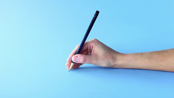 a hand holding a pencil to write with it